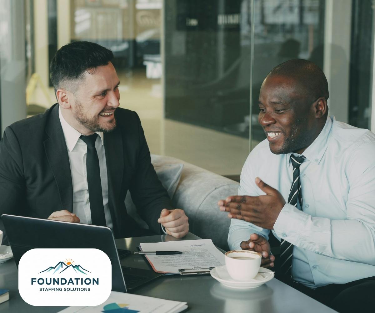 Small business owner reviewing staffing schedule with employees after hiring through Foundation Staffing Solutions